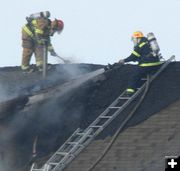 Hosing the roof. Photo by Clint Gilchrist, Pinedale Online.